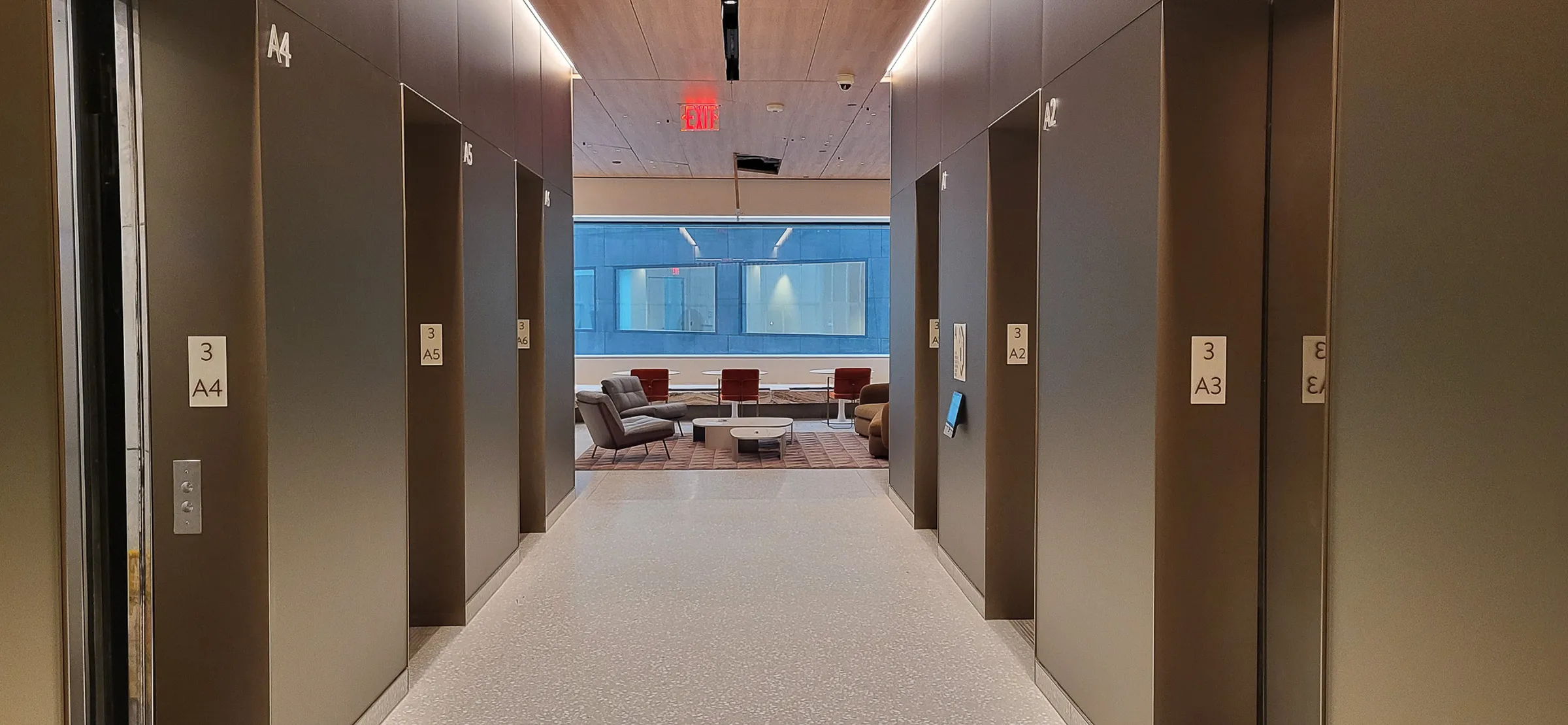 Corridor of elevator lobby with room identification signs